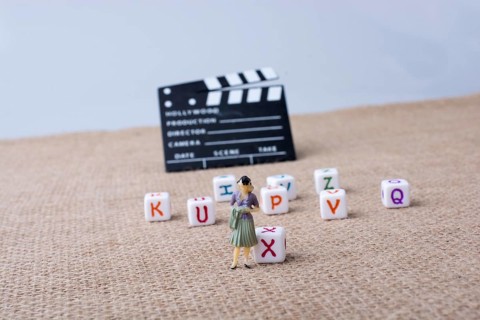 Colorful letter cubes beside a director clapper board