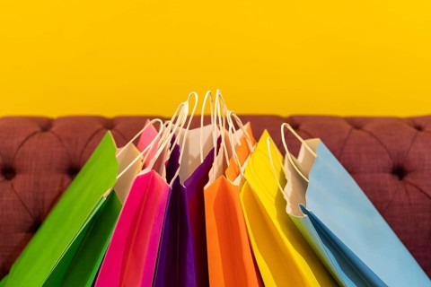 Shopping bags on the sofa. Yellow background. It can be use as a template