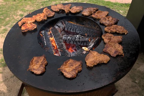 Ready-grilled pork steaks on an iron grill plate