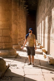 Young man in blue turban walking on the columns of the Edfu Temple near the city of Aswan. Egypt