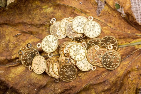 Plenty of fake gold coins are on a dry leaf