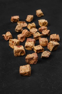 Dried animal lungs reward and treats for dogs scattered on black background