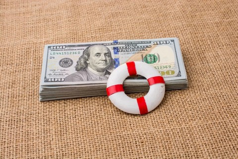 Life preserver placed on the banknote bundle of US dollar