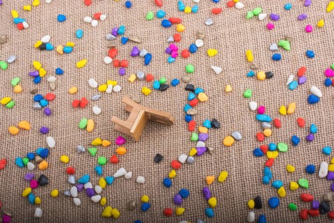 Little chair amid pebbles on canvas background