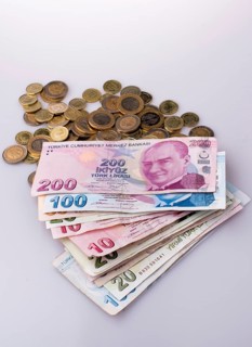 Turkish Lira coins and banknotes side by side on white background