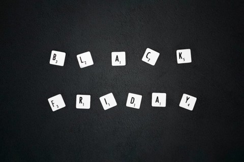 Black friday composition. Text on board game chips. Black textured background