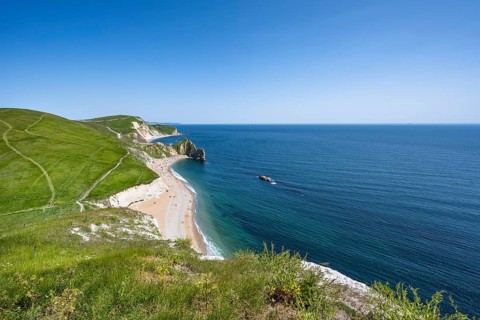 View over the chalk coast with the famous rock bridge Durdledoor