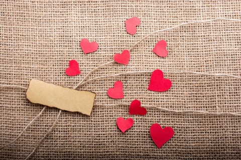 Love concept with heart shaped papers on linen threads