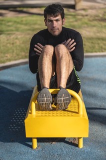 Attractive man doing sit-ups in the park