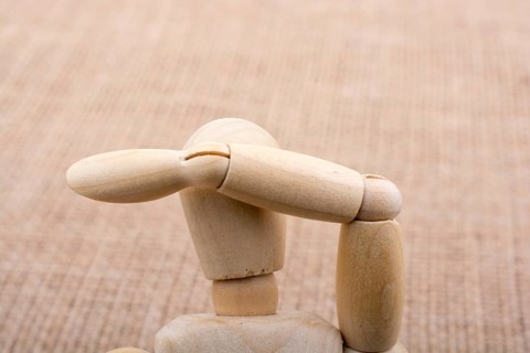 Wooden dolls of a man posing on canvas