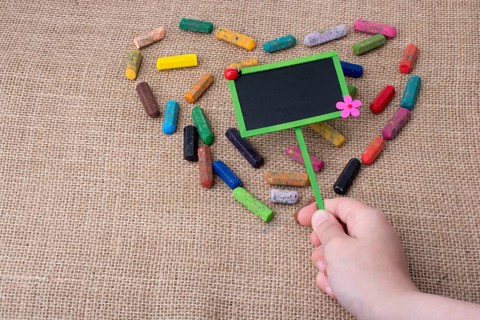 Notice board in the middle of crayons form a heart shape