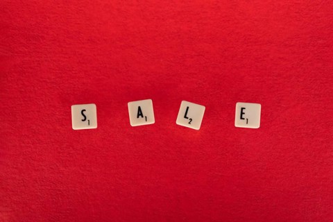 Sale composition. Text on board game chips. Red textured background