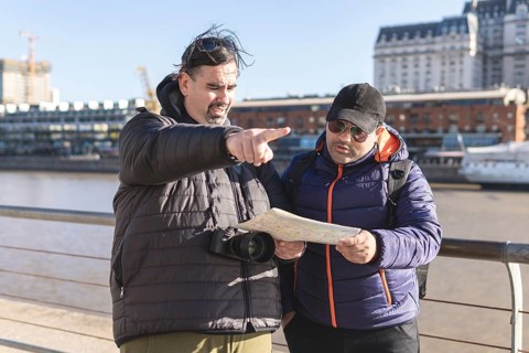 Couple of friends consulting the map while exploring Puerto Madero