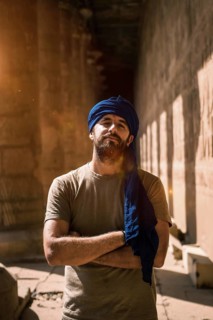 A young tourist in a blue turban visiting the Edfu Temple in the morning near Aswan city. Egypt
