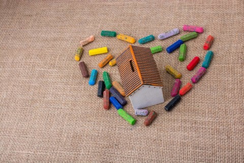 Globe in the middle of crayons form a heart shape