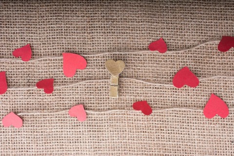 Love concept with heart shaped papers on linen threads