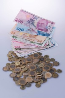Turkish Lira coins and banknotes side by side on white background