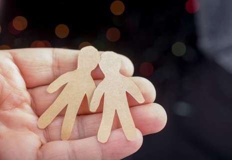 Paper man shape in hand on bokeh light background