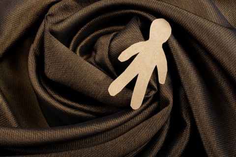 Man shape cut out of paper in hand in the view