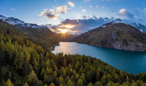 Aerial view at sunset over the autumnal forest at Lago di Luzzone in Valle di Blenio