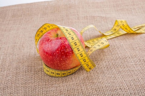 Health and diet concept with apple with a measurement tape