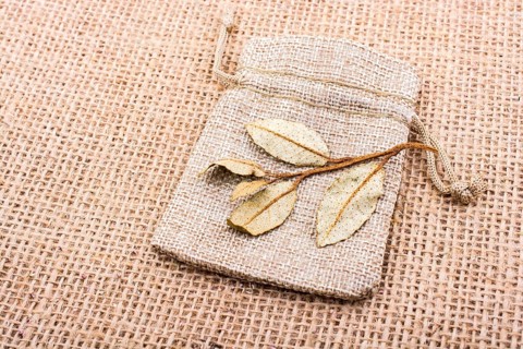 Dry green leaves on a sack on linen canvas