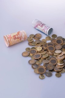 Turkish Lira coins and banknotes side by side on white background