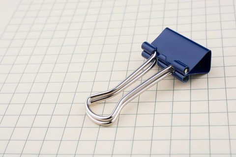 Colored paper clip on a checked notebook page