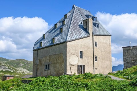 Rear view Side view with entrance to chapel in historic hotel accommodation Ospizio San Gottardo Saint Gotthard Hospice with historic building structure dating from 1237 13th century at 2091 metres hi...
