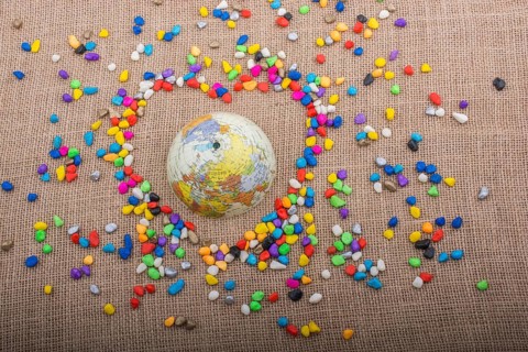 Globe in the heart form shaped by colorful pebbles