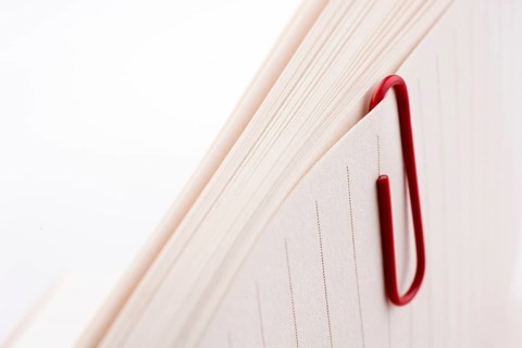 Colored paper clip on a checked notebook page