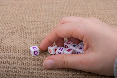 Colorful alphabet letter cubes in handon a canvas background