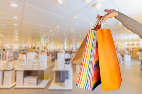 Shopping bags in the woman hands. Joy of consumption. Purchases