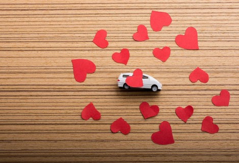 Love concept with model car and heart shaped papers