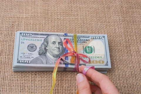 Banknote bundle of US dollar tied with colorful a ribbon
