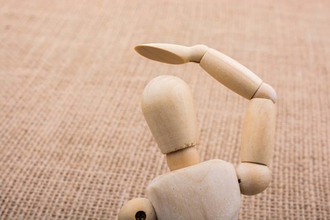 Wooden dolls of a man posing on canvas