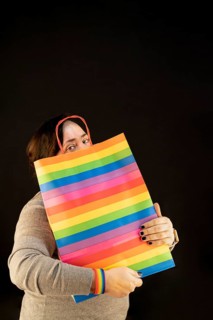 Woman holding lgbt bag. Joy of consumption. Purchases