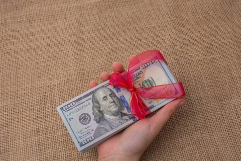 Banknote bundle of US dollar tied with colorful a ribbon