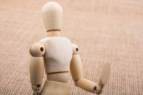 Wooden dolls of a man posing on canvas