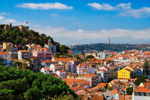 Lisbon famous view from Miradouro dos Barros tourist viewpoint over Alfama old city district with St. George's Castle and Portugal flag