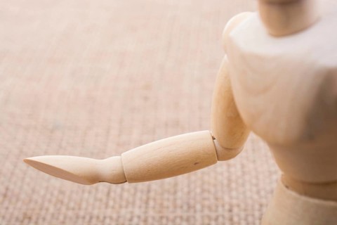 Wooden dolls of a man posing on canvas