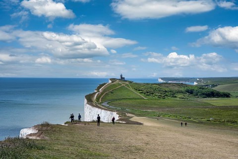 Tourists on the edge of the chalk cliffs at Beachy Head