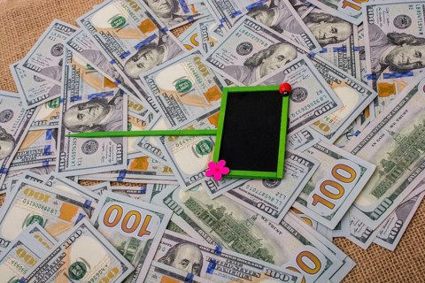 Notice board placed on spread US dollar banknotes