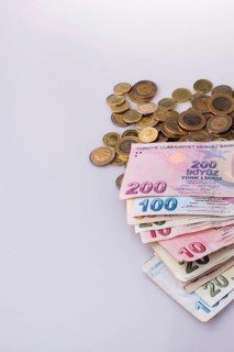 Turkish Lira coins and banknotes side by side on white background