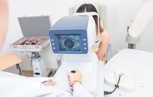 Optometrist using refractometer with patient. Eyesight of a patient on the screen of the refractometer