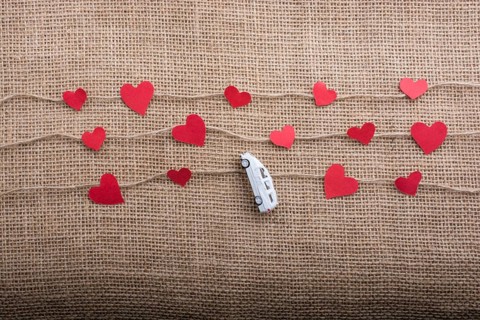 Love concept with car and paper heart on linen threads