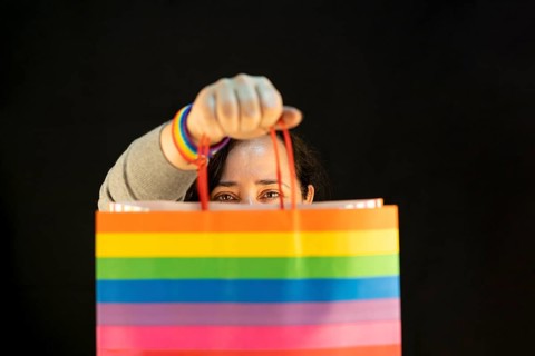 Woman holding lgbt bag. Joy of consumption. Purchases