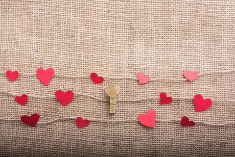 Love concept with heart shaped papers on linen threads