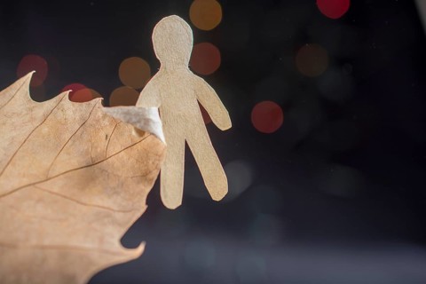 Paper man shape in hand on bokeh light background
