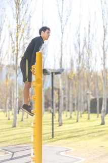 Young man doing climbing vertical exercise in the park